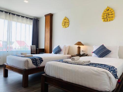 清迈Ç精品舒适酒店 的酒店客房设有两张床和窗户。