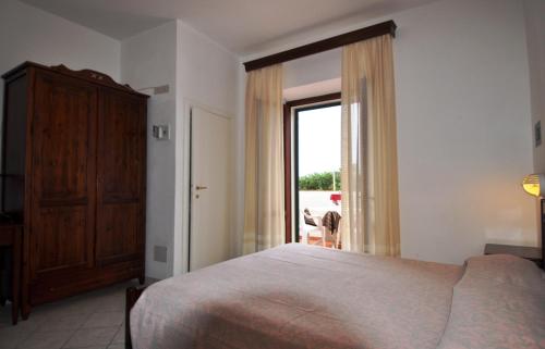 马尔恰纳Hotel Belmare的一间卧室设有一张床和一个大窗户