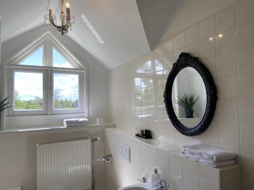Deil牛马酒店的白色的浴室设有镜子和水槽