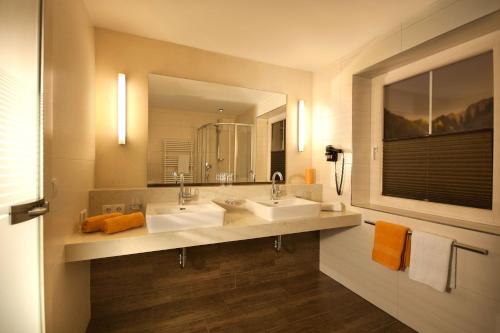 迈尔霍芬加尼克瑙尔别墅酒店的一间带两个盥洗盆和大镜子的浴室