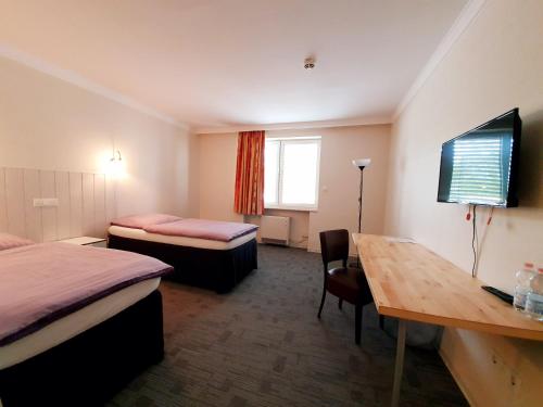 陶努斯山麓霍夫海姆Hotel Pause的酒店客房设有两张床、一张桌子和一张桌子。