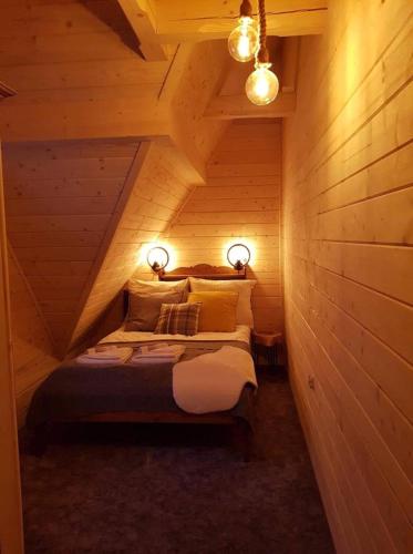 希切玛尔Śwarny Domek的小木屋内一间卧室,配有一张床