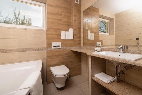 OlesnoHotel Olesno的浴室配有卫生间、盥洗盆和浴缸。