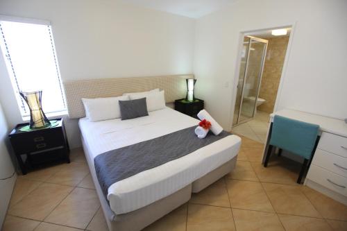 拉罗汤加莫阿纳沙滩别墅公寓的一间带白色大床的卧室和一间浴室