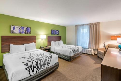 斯波坎Sleep Inn Spokane Airport的酒店客房,设有两张床和一张沙发
