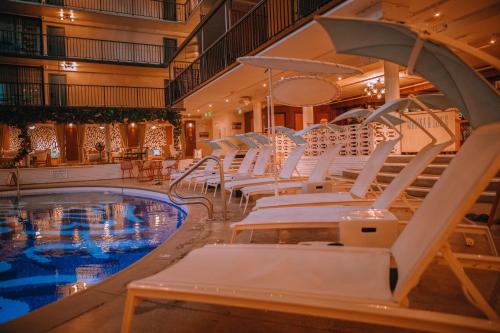 檀香山冲浪顶酒店及游泳俱乐部的游泳池旁的游泳池配有白色躺椅
