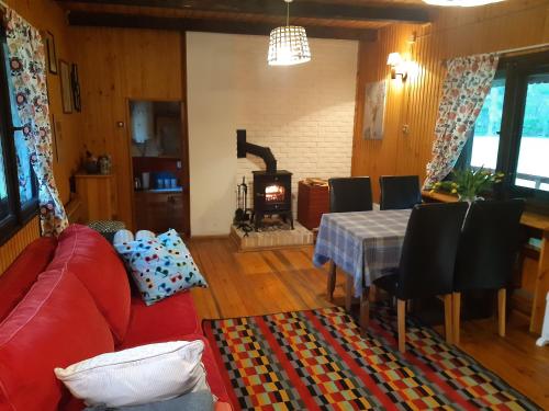 古日诺Leśna Polana的客厅配有红色的沙发、桌子和壁炉