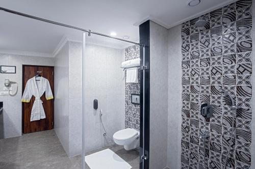 甘托克Lemon Tree Hotel Gangtok的一间带卫生间和玻璃淋浴间的浴室