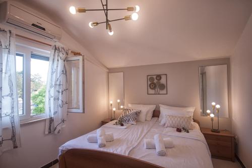 马林斯卡Apartments Katarina Porat的卧室配有一张带白色床单和枕头的大床。