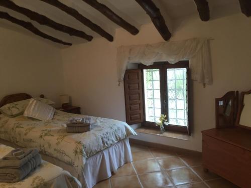 ArboleasCortijo Esquina B&B Guesthouse的一间卧室设有两张床和窗户。
