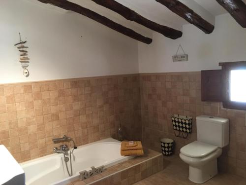 ArboleasCortijo Esquina B&B Guesthouse的带浴缸和卫生间的浴室。