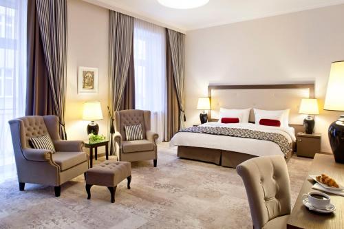 克拉科夫大都会精品酒店的酒店客房,配有床和椅子