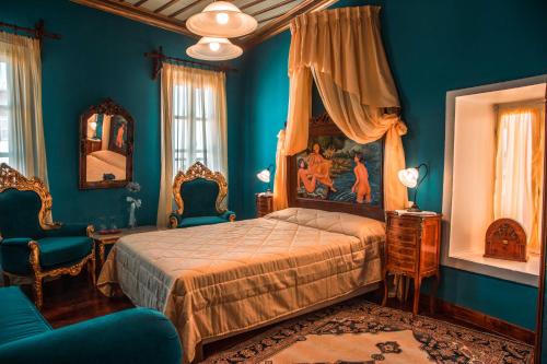 纳夫普利翁伊利安酒店的卧室拥有蓝色的墙壁,配有一张床和椅子