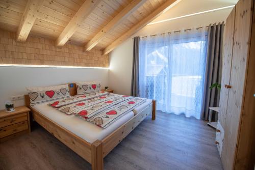 克里姆尔Ferienwohnung Trocker的一间卧室设有一张床和一个大窗户