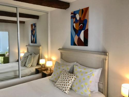 穆斯捷-圣玛丽La Maison du Courtil, Citron-Caramel的卧室配有一张床,墙上挂有绘画作品