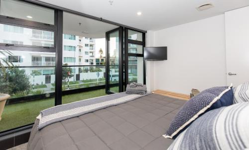 芒格努伊山Ocean Eleven 22的一间卧室设有床铺和大型玻璃窗