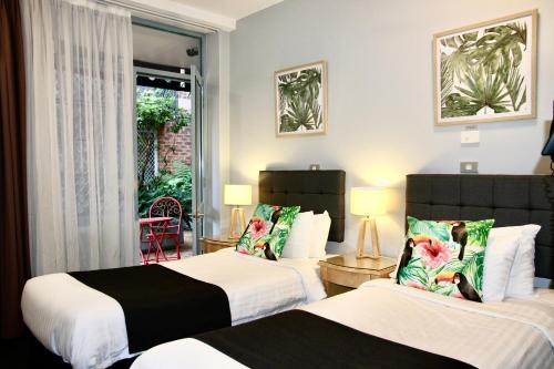 悉尼Mariners Court Hotel Sydney的酒店客房设有两张床和窗户。