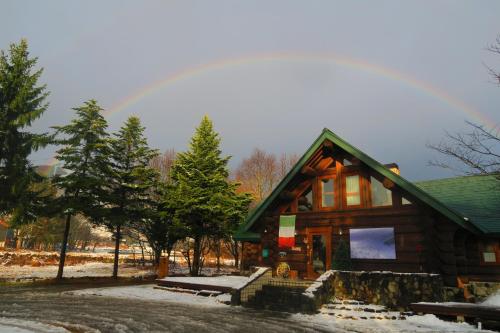白马村白马休息酒店的小木屋的背景是彩虹