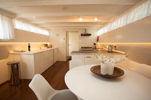 阿姆斯特丹Prince Royal B&B的小厨房配有白色的桌子和白色的椅子