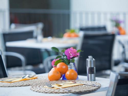 福纳卢奇Fornalutx Petit Hotel - Bed & Breakfast的一张桌子上放着橙子和花瓶
