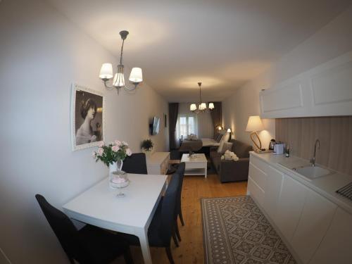 班斯卡 - 什佳夫尼察Wise Owl Apartments的厨房以及带白色桌椅的起居室。