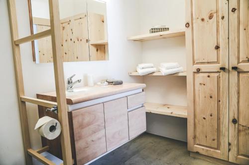 施库尔Il Maschun im historischen Engadinerhaus的一间带水槽和木制橱柜的浴室