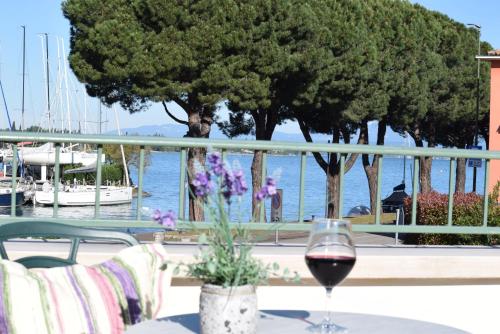 佩斯基耶拉德加达特拉托利亚菲亚拉瓦特酒店的一张桌子上的一杯葡萄酒,享有水景