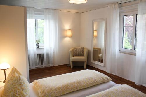 代特莫尔德Ferienwohnung am Stemberg的一间卧室配有一张床、一把椅子和窗户。