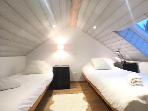 维尔雅尔姆B&B Pegasus II - Chambre de luxe avec sauna privatif的天花板客房内的两张床