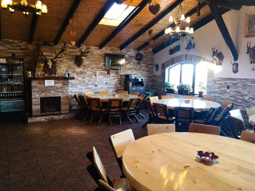 丰达塔Pensiunea Edera的餐厅设有木桌和椅子,拥有砖墙