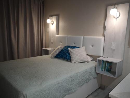 马盖特Uvongo Chalet 11的一间卧室配有一张带两个枕头的床
