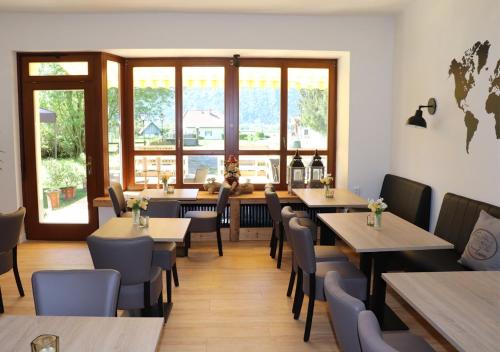 NötschPension Leano的餐厅设有木桌、椅子和窗户。