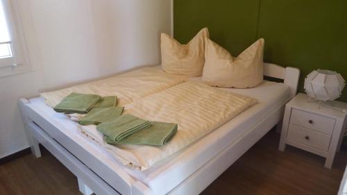 布尔格Ferienhäuser Stübgen的一张白色的床,上面有两条绿色毛巾