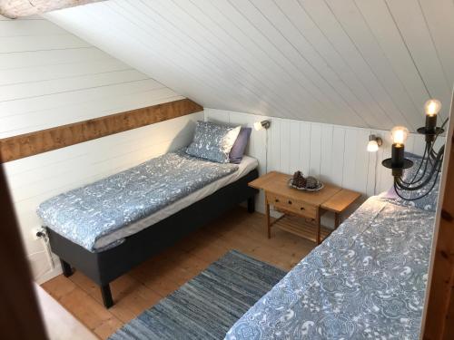 胡迪克斯瓦尔Seaside Cottage House nr 1, Saltvik Hudiksvall的阁楼间设有两张床和一张桌子