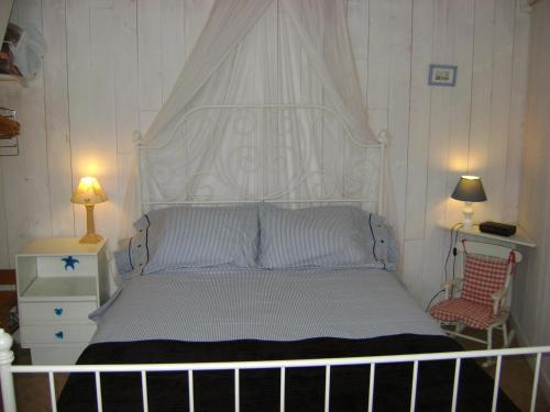 拉弗洛特新岛小度假屋的卧室内的一张带白色床头板的床