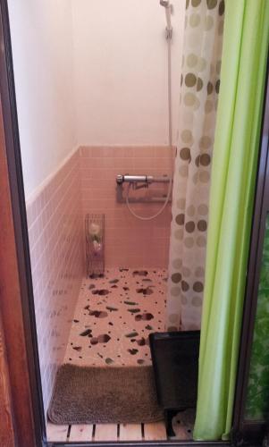 松本松本背包客旅馆的一间铺有瓷砖地板的带淋浴的浴室