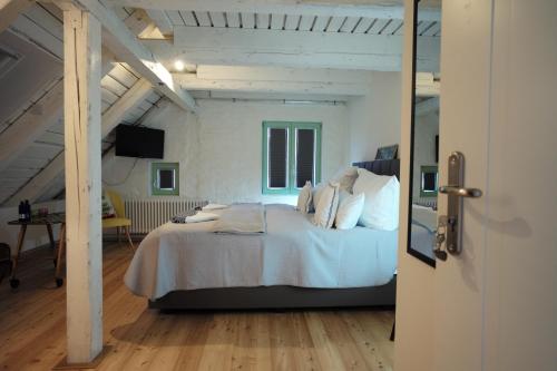 奥斯特巴德·哥伦Pension Zum grünen Kakadu的一间卧室配有一张带白色床单的床和一扇窗户。