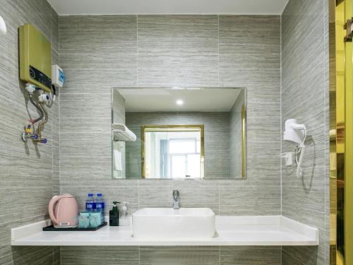 广州四月精品复式公寓广州南站奥园越时代店的一间带水槽和镜子的浴室