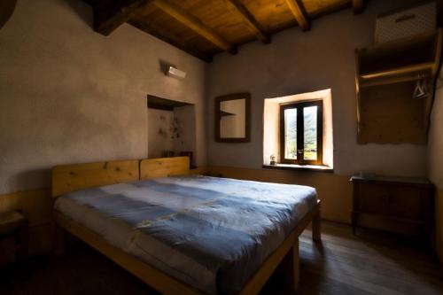 PolinagoOstello Podesteria di Gombola - arte e territorio的一间带床的卧室,位于带窗户的房间内