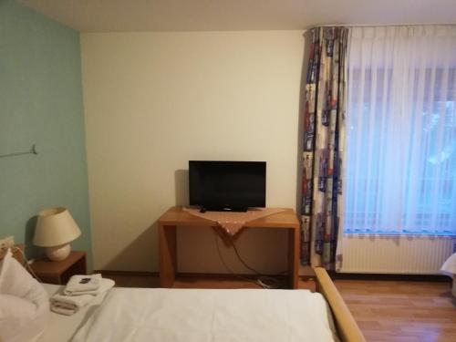 Biberach-UmmendorfHotel Linde的一间卧室配有一张床和一张书桌及电视