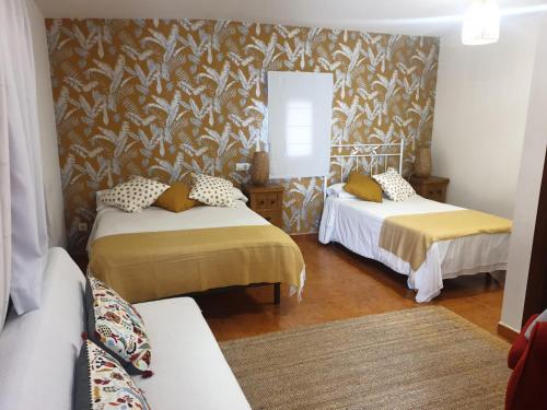 伊诺赫多El Bodegon de Luis的一间设有两张床和一张沙发的房间