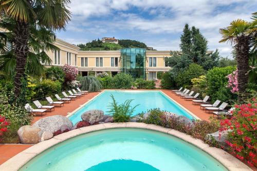 Coccaglio旅游酒店的一座带椅子的游泳池以及一座建筑