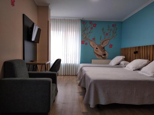 卢戈布里斯旅馆的酒店客房设有两张床,墙上挂着鹿头