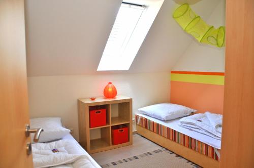 马林费尔德Ferienhaus Müritzsonne / OG-Appartement的小房间设有两张床和天窗