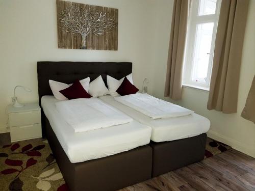巴特萨尔茨乌夫伦Villa zur schönen Aussicht的一间卧室配有带白色和红色枕头的床
