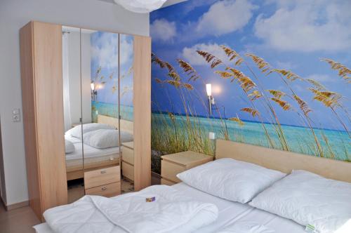 马林费尔德Ferienhaus Müritzbrise / EG-Appartement的一间卧室配有两张床,并拥有海滩壁画