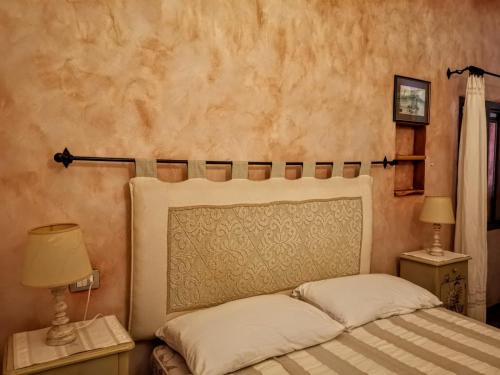 阿比亚多利Villa La Quercia - Capriccioli的一间卧室配有一张床和两个带灯的床头柜