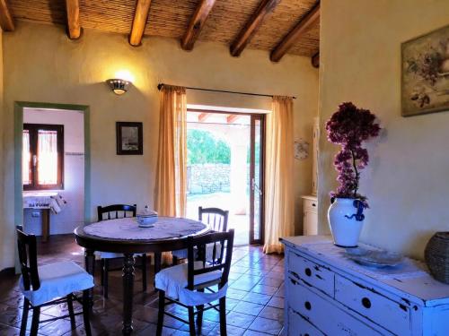 阿比亚多利Villa La Quercia - Capriccioli的一间用餐室,在房间内配有桌椅