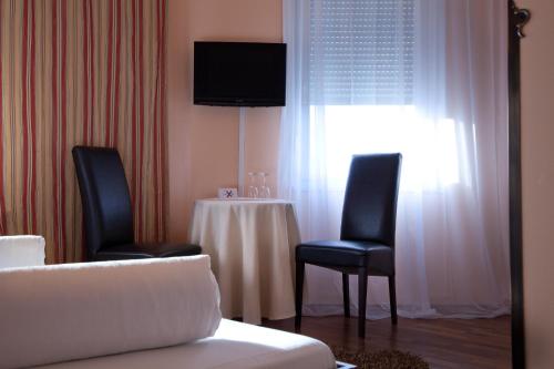路德维希堡里维埃拉酒店的一间配备有桌子和两把椅子及一台电视的房间