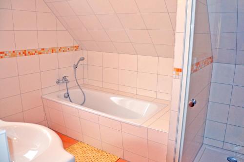 马林费尔德Ferienhaus Müritzbrise / OG-Appartement的带浴缸、卫生间和盥洗盆的浴室